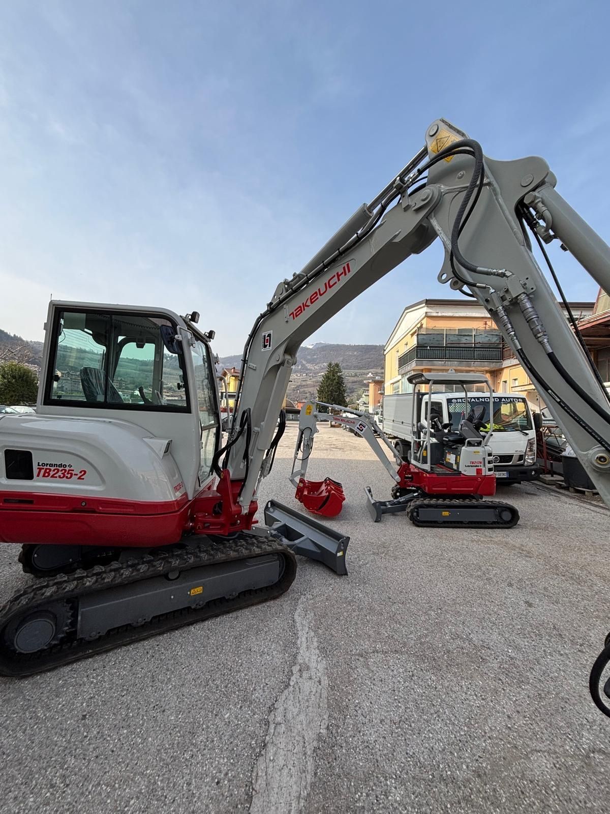 Escavatore cingolato e mini escavatore parcheggiati in un piazzale